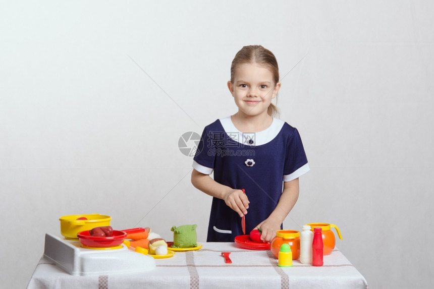 女孩在桌子上玩厨房玩具图片