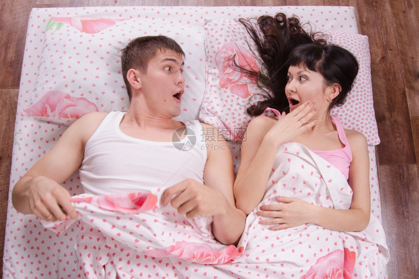 不熟悉的年轻女孩和男人在床上醒来图片