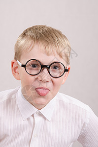 12岁男孩戴眼镜坐在椅子上架舌头背景图片
