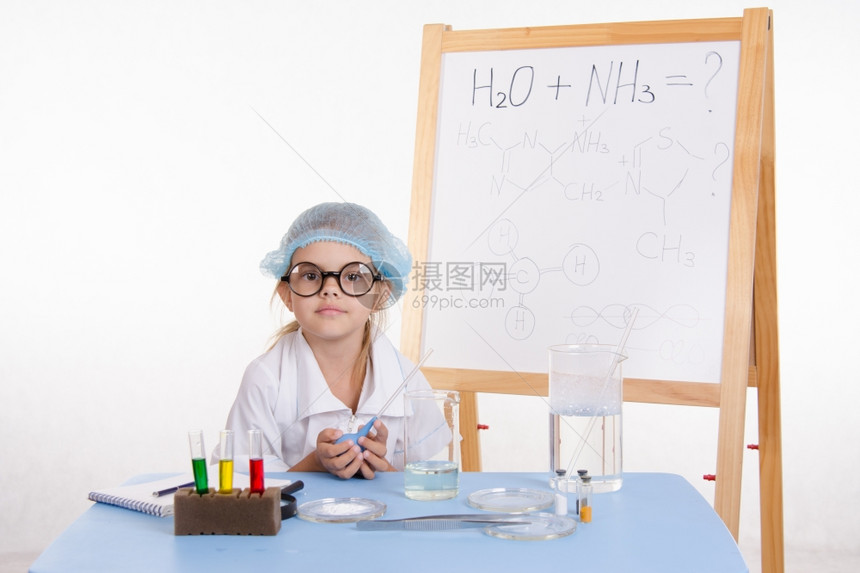 女孩坐在桌上做化学课的试剂和实验图片