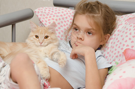 女孩和一只小猫躺在床上图片