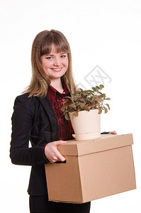 在办公室工作时被收养的微笑女孩拿着装有东西的盒子图片