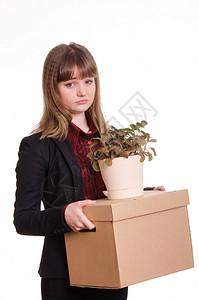 悲伤的女孩从她工作中被开除并拿着一个装东西的盒子图片