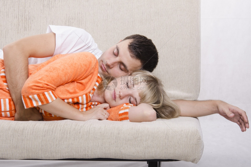 睡在沙发上的年轻夫妇那家伙从后面抱起她的怀图片