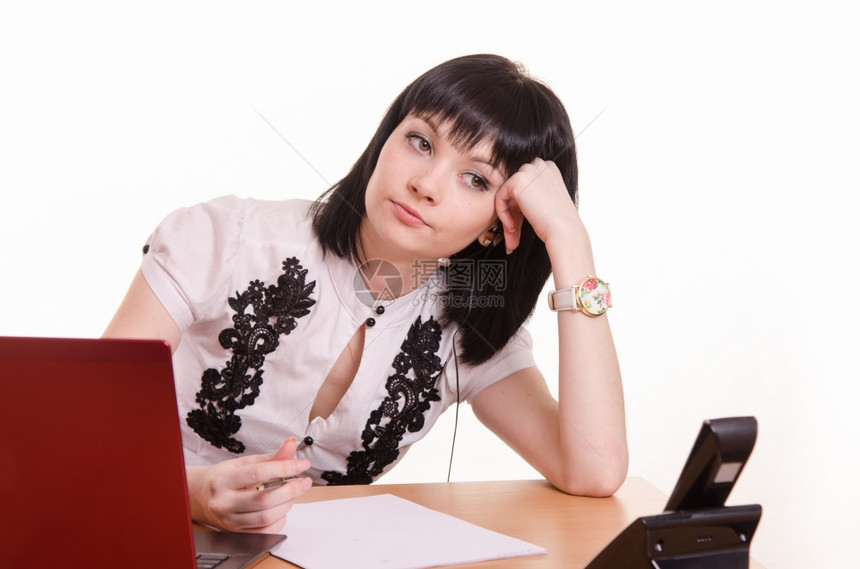 坐在呼叫中心桌子上的可爱小女孩穿着白色上衣的笔记本电脑将头部踩在手上图片