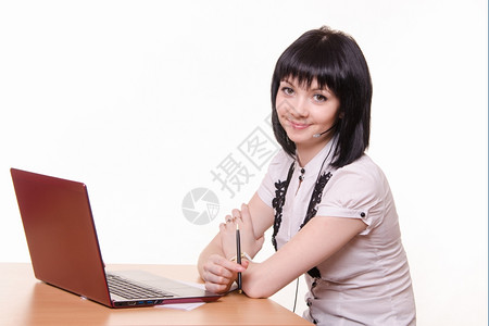 坐在呼叫中心的桌子上穿着白色衣的笔记本电脑可爱的小女孩图片
