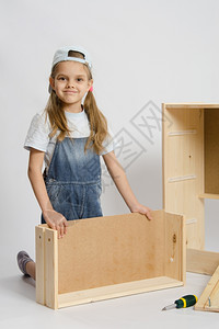 6岁女孩玩耍和收集木制柜子图片