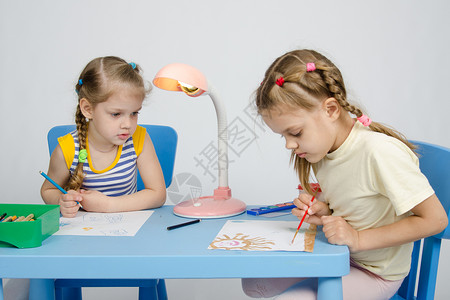 两姐妹坐在桌子上写字图片