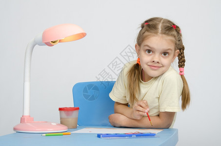 女孩坐在桌子上绘画图片