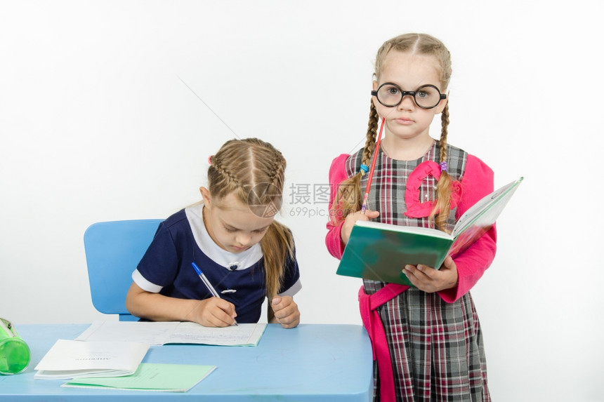 两个女孩扮演学校教师和生的角色图片