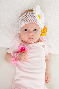 一个两月的欧洲女婴背着绷带头部被包上绷带一朵花躺在张柔软的床上图片