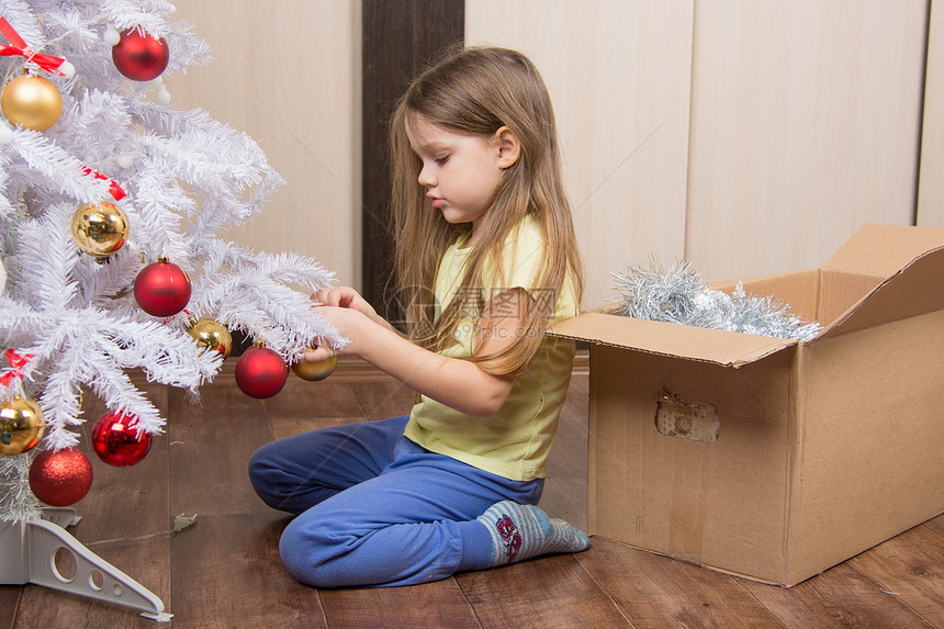 悲伤的女孩拿了圣诞树和玩具悲伤的5岁女孩拿了一只玩具人造圣诞树图片