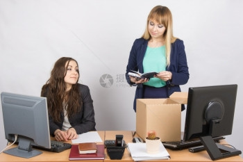 坐在办公桌的两名年轻漂亮商业女青年被分为两个工作图片