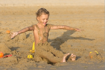 儿童坐在沙滩上玩沙子图片