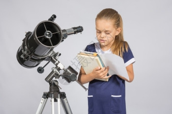 在望远镜上站立天文学家时在校女生读教科书图片