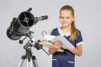 女学生天文家站在望远镜旁的书里叶子图片