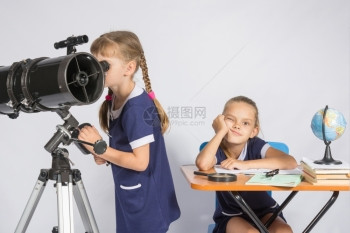 一个女孩透过望远镜看另一个女孩在等待结果图片