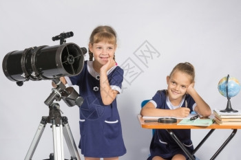 一个女孩在操作望远镜另一个女孩嘲笑她图片