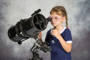 女孩通过望远镜观察星星图片