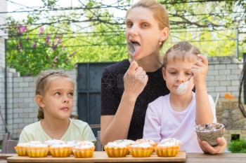母亲和两个女儿舔勺子图片