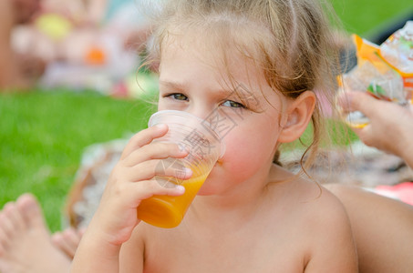 女孩喝着塑料可支配杯子里的果汁图片