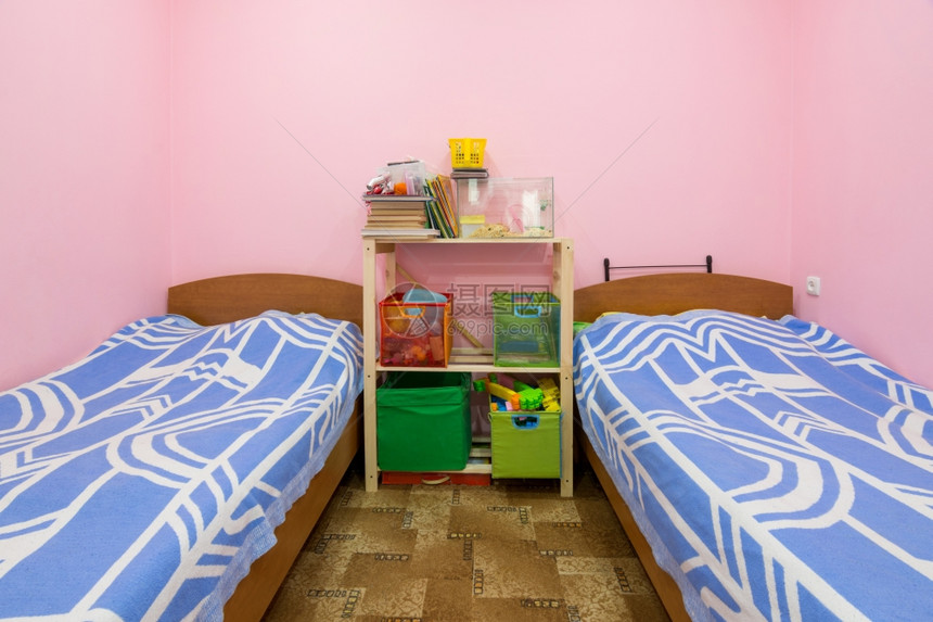一个小宿舍室内中间有两张床和一自制架图片