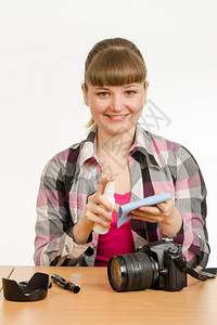 女摄影师对照相机身体进行清洁防止外部污染图片