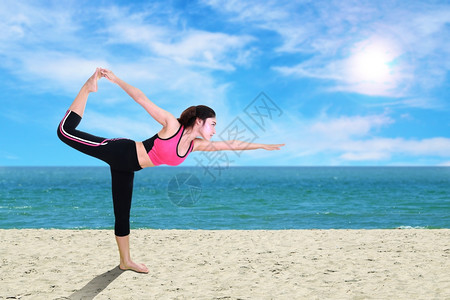 在沙滩上做瑜伽锻炼的年轻女子图片
