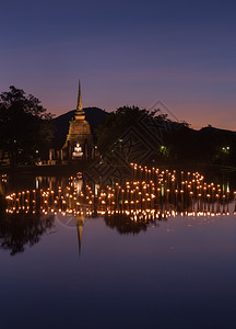 泰国Sukhothai历史公园LoyKratong节寺庙佛像上的光图片