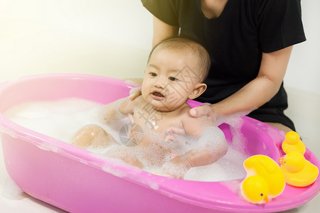 婴儿在浴缸洗澡家里玩泡沫图片