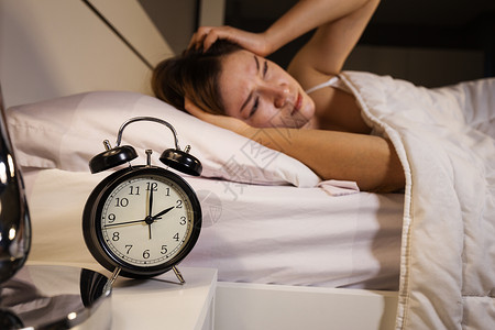 时钟显示2点女人在床上睡不着图片