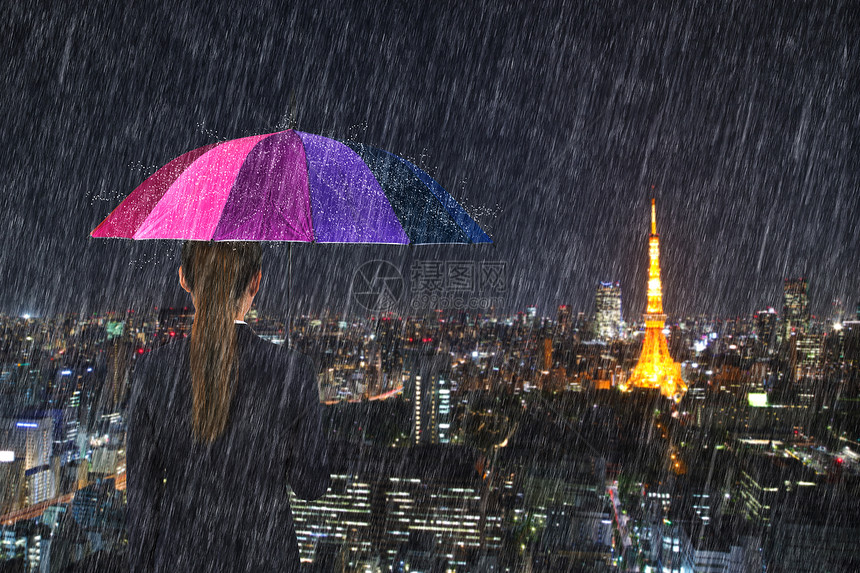 日本东京市风雨下拥有多彩伞的女商人图片