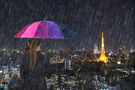 日本东京市风雨下拥有多彩伞的女商人图片