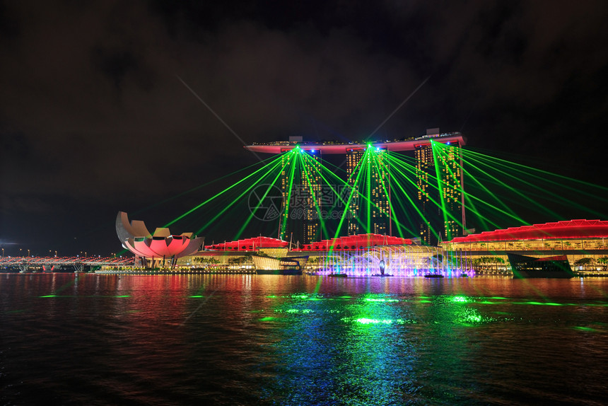 新加坡市晚上在码头水面上展出美丽的激光表演图片