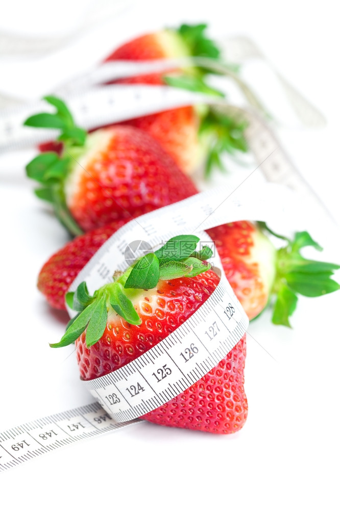 长大多汁红色的熟草莓和测量胶带在白色上隔离图片
