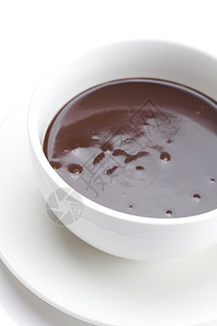 在一个孤立白色上的杯子里融化巧克力图片