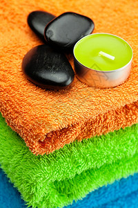三条多彩浴巾黑石和蜡烛背景背景图片