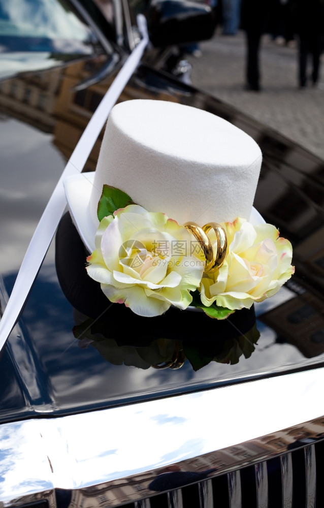 在汽车引擎盖上戴帽子形式的婚礼装饰图片