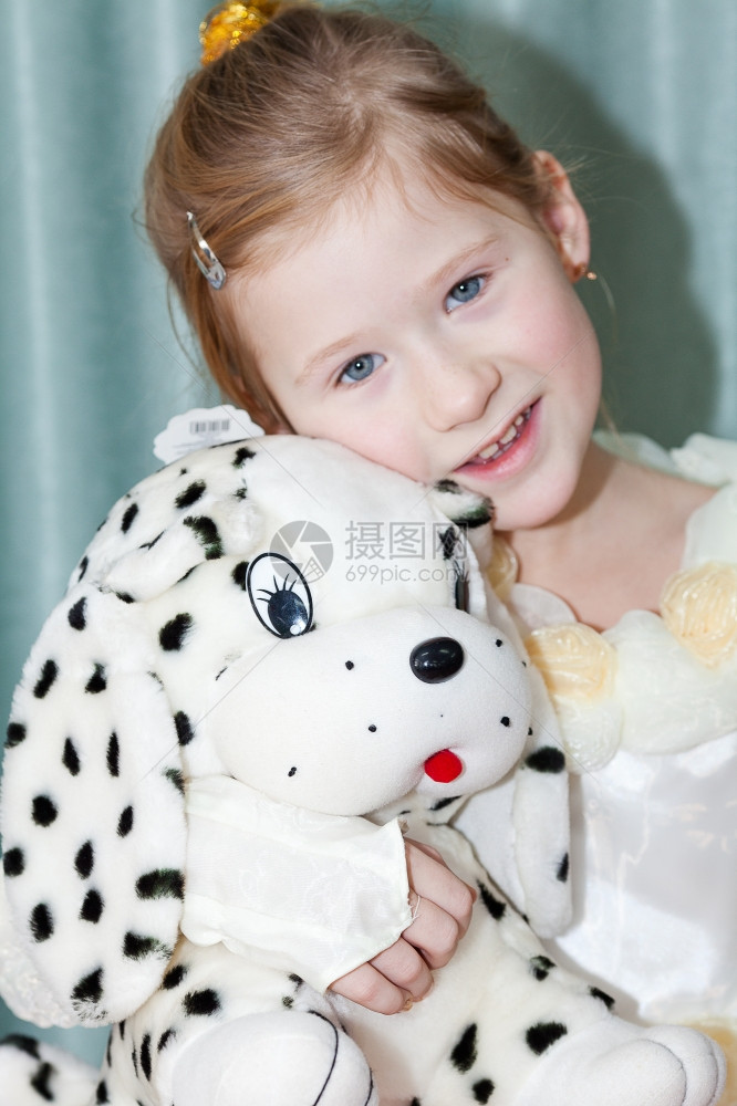 一个带着玩具狗的漂亮小女孩肖像图片