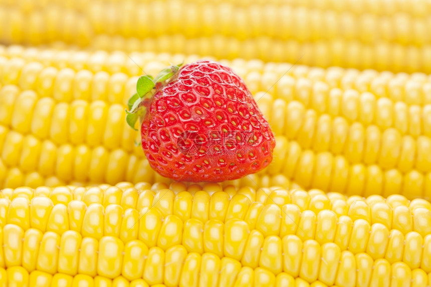 成熟的黄玉米和草莓背景图片