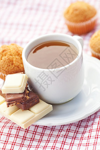 方格餐布上的巧克力热茶和松饼图片