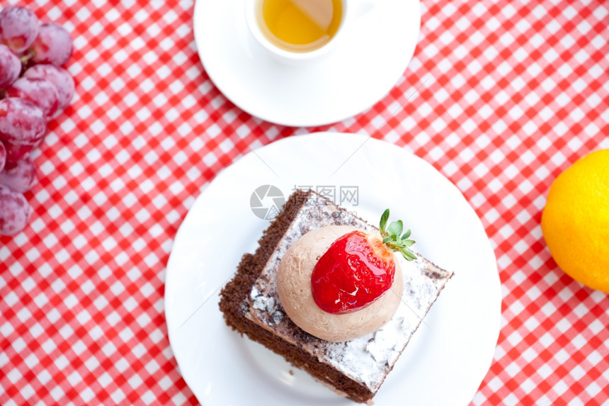美丽的蛋糕草莓野和茶在格布织物上图片