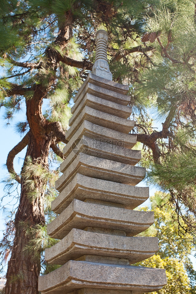 绿树背景的石塔图片