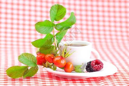 茶杯黑莓草玫瑰果和花生子以白边织布为树叶图片