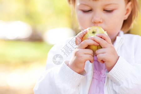 小女孩在森林里吃苹果图片