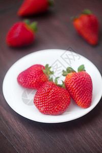 木质表面板块上的红色多汁草莓背景图片