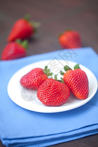 木质表面板块上的红色多汁草莓背景图片