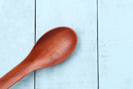 蓝木地板上的勺子手器和烹饪的概念图片