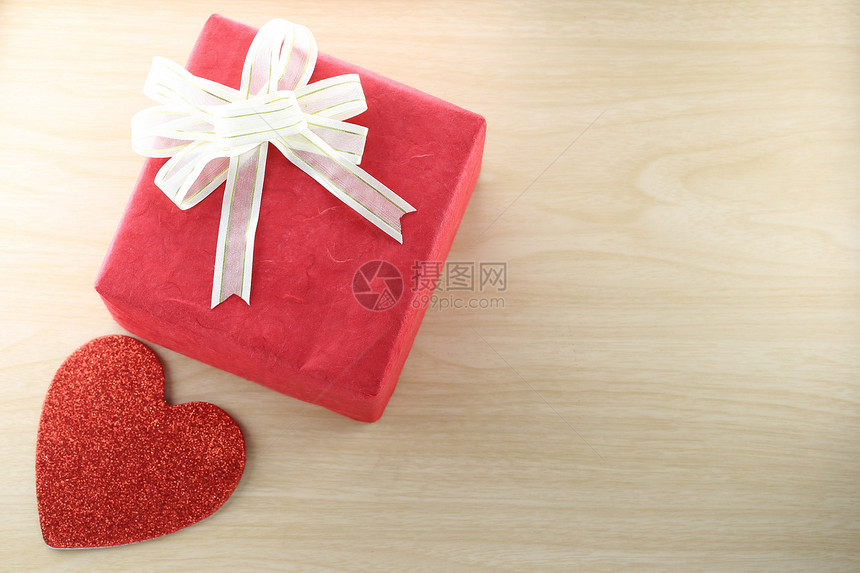空书和红礼盒在木上贴近心形空书和红礼盒在木地板上贴近心形这是圣诞节和情人的概念图片
