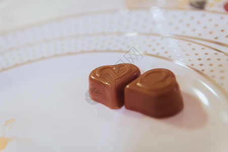 白色盘子上两个心形巧克力的缝合图片